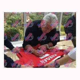 Man signing a red shirt at a signing event, fans around him indoors with 'All-Star' watermark over image