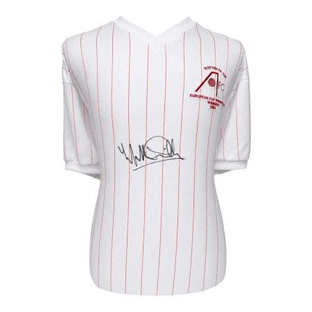 willie-miller-aberdeen-shirt Υπογεγραμμένη λευκή ριγέ ποδοσφαιρική φανέλα με κόκκινες κάθετες ρίγες και έμβλημα που γράφει Κυπελλούχοι Ευρώπης 1965 στο στήθος.