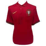 Red polo shirt featuring the Portugal crest on the left chest and a gold Nike swoosh on the right, with a black-and-green striped cuff and a signature across the front.
