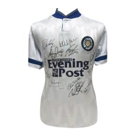 White Leeds United jersey with blue trim, covered in signatures, featuring Evening Post sponsor logo.