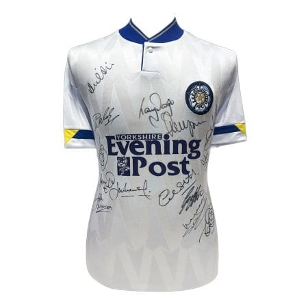 leeds-1992-shirt-x14 White signed football shirt with club crest on chest, Yorkshire Evening Post sponsor logo, and blue-yellow sleeve accents; numerous autographs across the front.