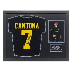 Framed display featuring a black Cantona Manchester United jersey with yellow number 7 and autograph, plus a small photo plaque and caption